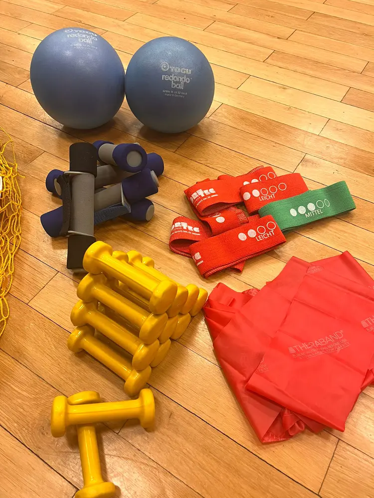 Eine Gruppe von Frauen in warmer Kleidung, die beim Walking-Treff auf einem Pfad in einer nebeligen Landschaft mit Wanderstöcken spazieren geht.